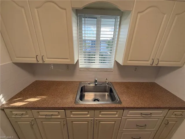 Kitchen featuring a sink and white cabinets