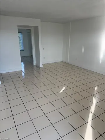 Spare room featuring light tile patterned floors and baseboards