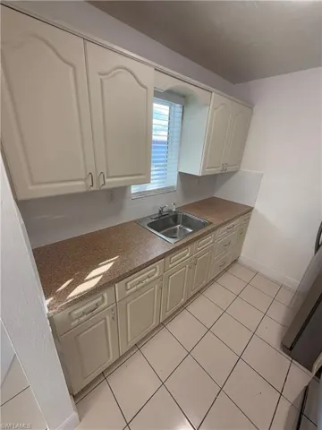 Kitchen featuring white cabinetry and light tile patterned floors