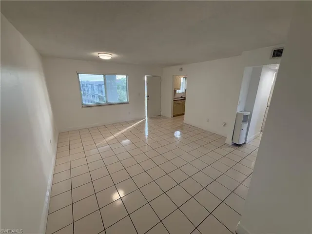 Empty room featuring baseboards and light tile patterned floors