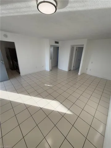 Unfurnished room with a textured ceiling and light tile patterned floors
