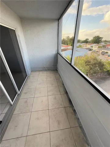 Unfurnished sunroom featuring tile patterned flooring and a textured wall