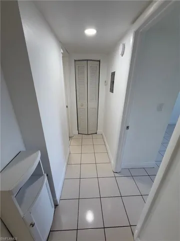 Hall featuring baseboards and light tile patterned floors