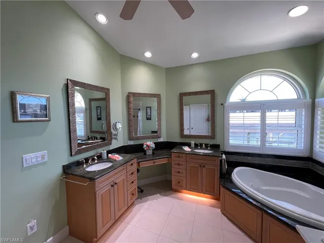 Master Bathroom with double vanity, tile patterned floors, a ceiling fan, and a sink
