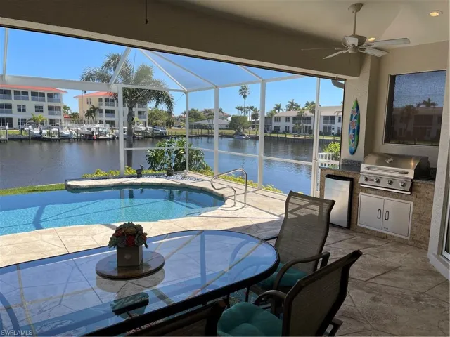 Pool with a patio, area for grilling, a water view, grilling area, and a lanai