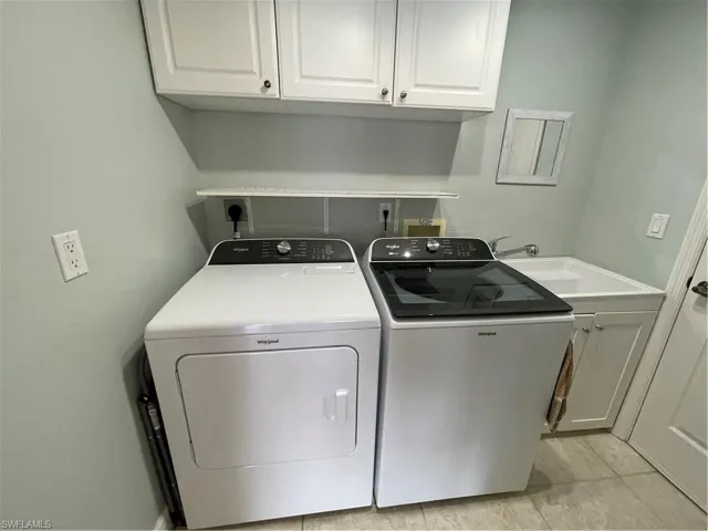 Laundry room with a sink, cabinet space, and washing machine and clothes dryer