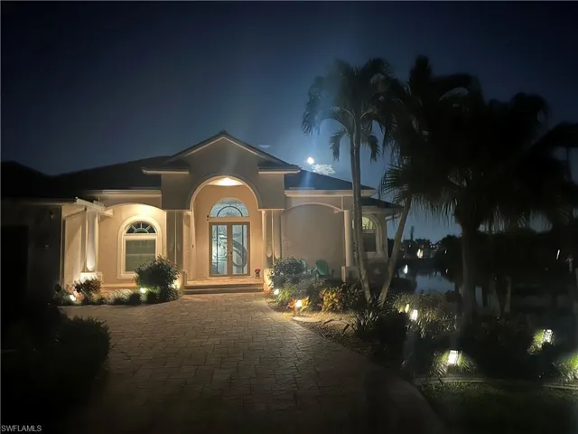 View of front of home with french doors, driveway, and stucco siding