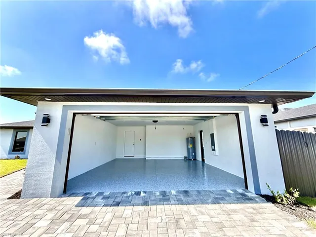 Garage with decorative driveway and water heater
