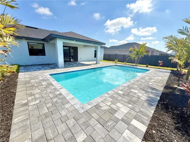 View of pool with patio surround and a fenced backyard