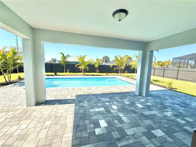 View of swimming pool with patio surround and a fenced backyard
