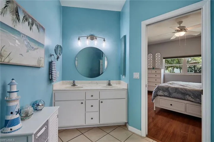 Bathroom with ensuite bath, double vanity, and a ceiling fan
