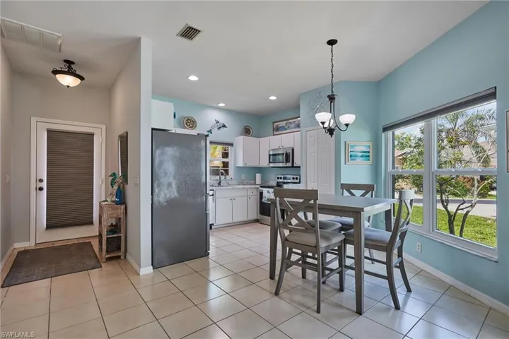 Dining area with a chandelier, light tile patterned flooring, and recessed lighting