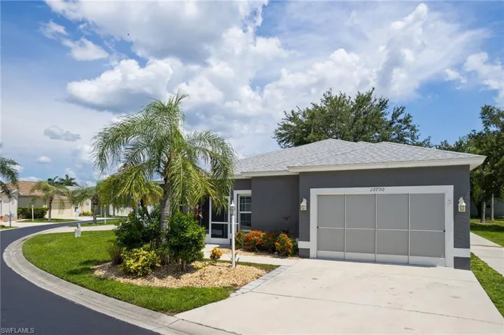View of front facade featuring concrete driveway, a garage, stucco siding, and roof with shingles