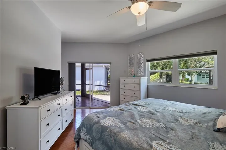 Bedroom featuring access to outside, dark wood-style flooring, and ceiling fan