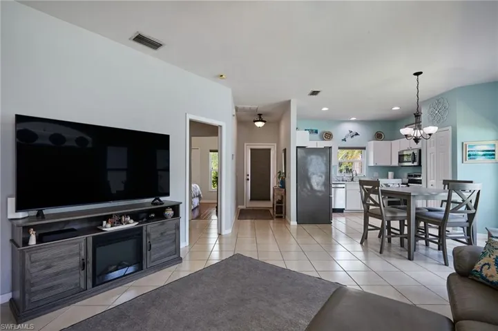 Living room featuring a chandelier, light tile patterned floors, and recessed lighting