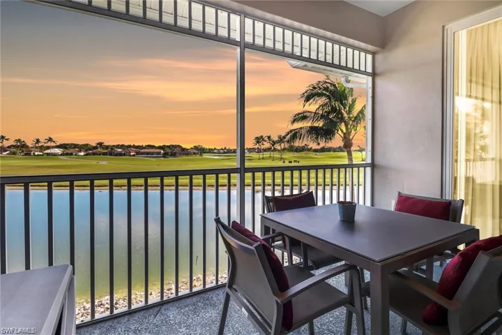 Sunroom with golf course view and a water view