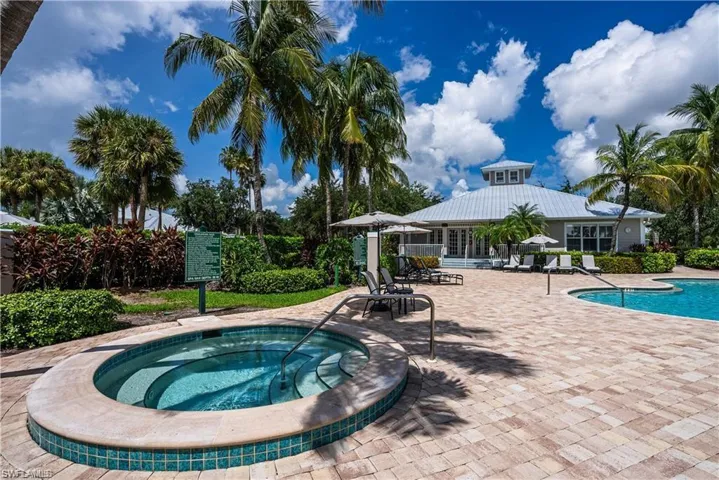 Community pool with a patio area and a hot tub