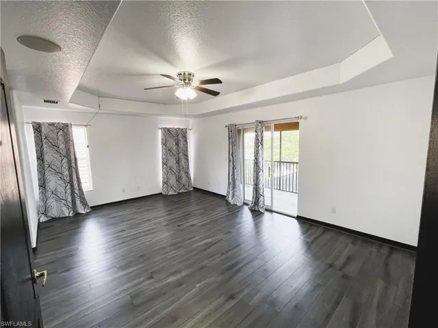 Spare room featuring ceiling fan, a textured ceiling, and dark hardwood / wood-style floors