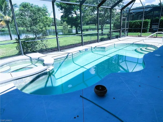 View of pool featuring a lawn, a water view, and a lanai