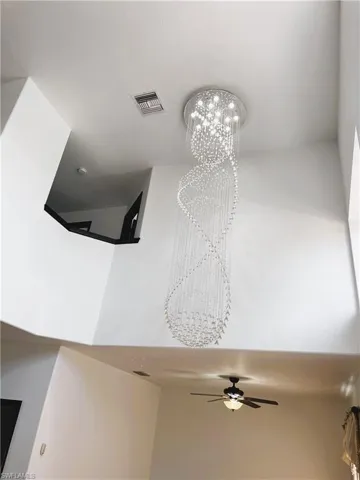 Details with ceiling fan with notable chandelier