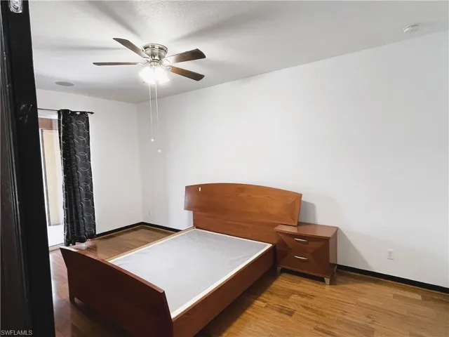 Bedroom with ceiling fan and hardwood / wood-style floors