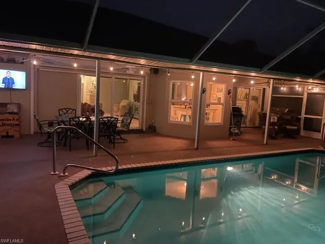 View of pool featuring a sunroom, a pool, and glass enclosure