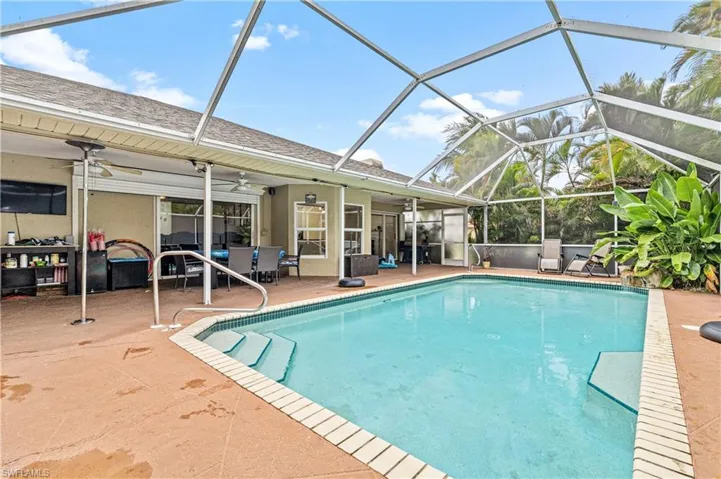 Swimming pool featuring a lanai, a patio area, and a sunroom