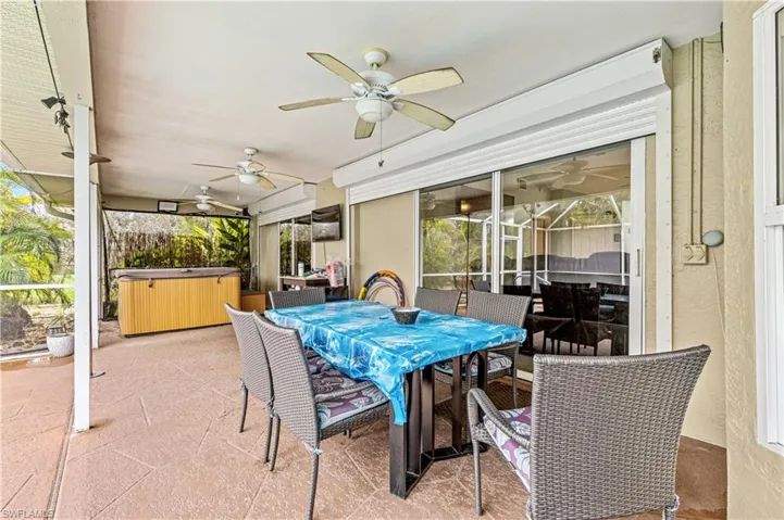 View of patio featuring outdoor dining area, a hot tub, and ceiling fan
