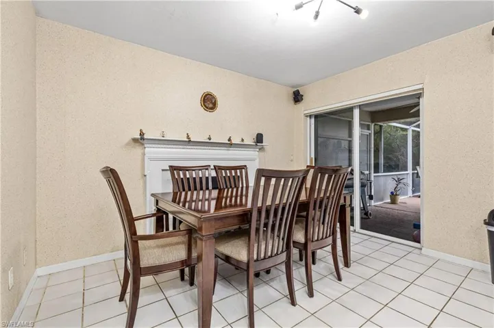 Dining area with light tile patterned floors and fireplace