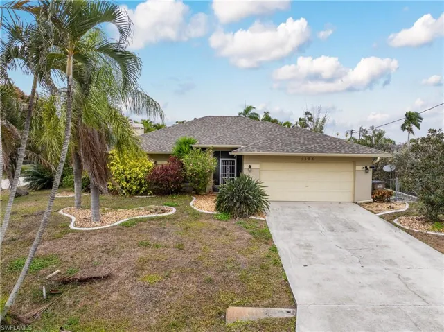 Single story home with driveway, an attached garage, a shingled roof, and a front lawn