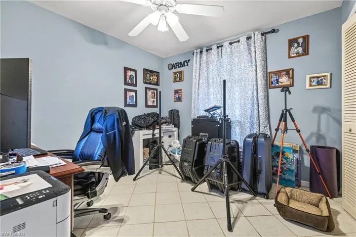 Home office with light tile patterned floors and a ceiling fan