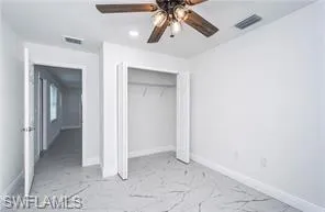 Unfurnished bedroom featuring recessed lighting, ceiling fan, a closet, and light marble finish flooring