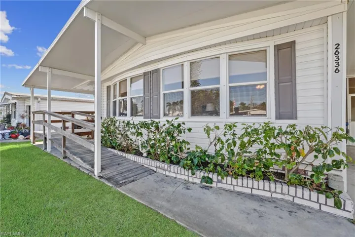 Property entrance featuring a lawn and covered porch