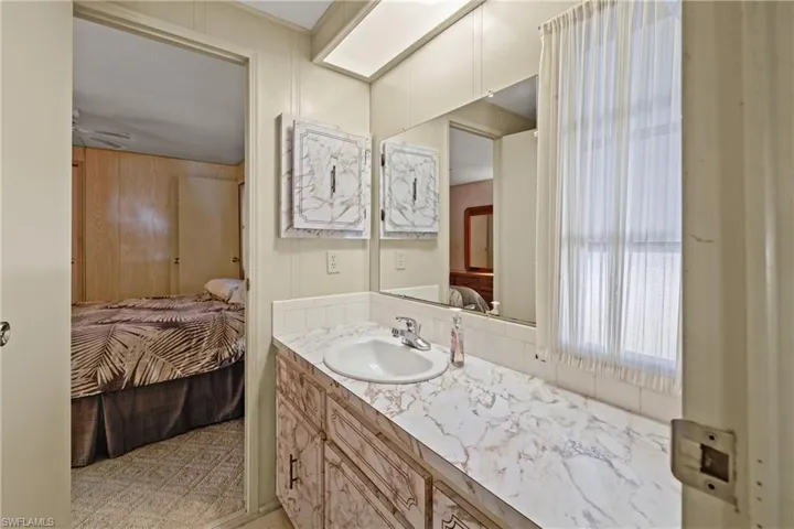 Bathroom featuring wooden walls, vanity, and ceiling fan