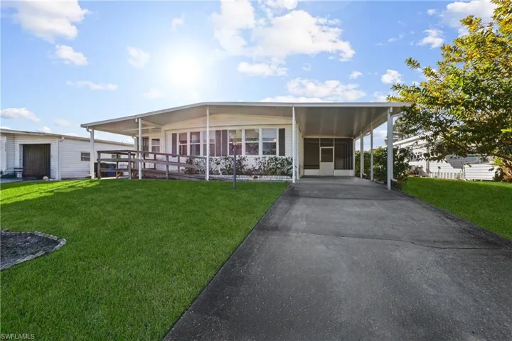View of front of house featuring a front yard and a carport
