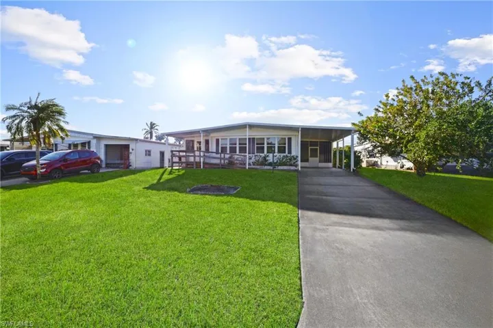 View of front facade with a front yard and a carport