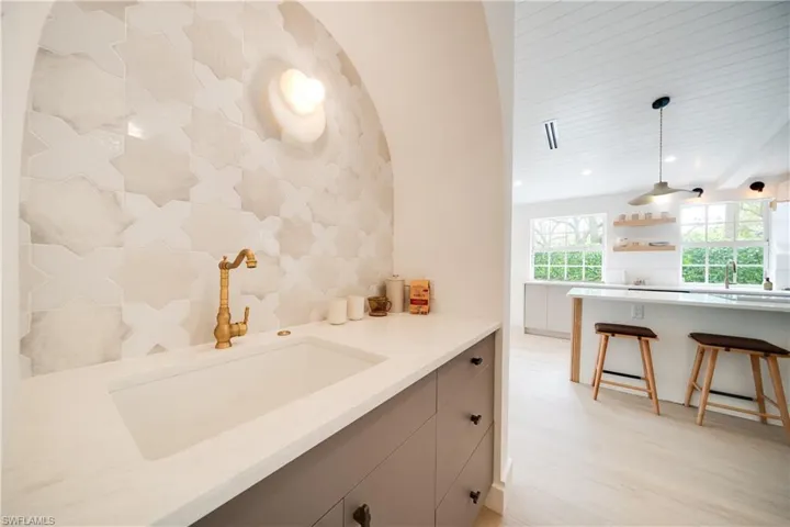 Kitchen with decorative light fixtures, light wood-style floors, open shelves, a sink, and recessed lighting