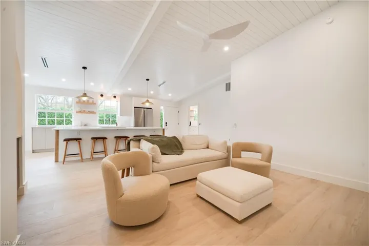 Living room with light wood finished floors, recessed lighting, wood ceiling, and baseboards