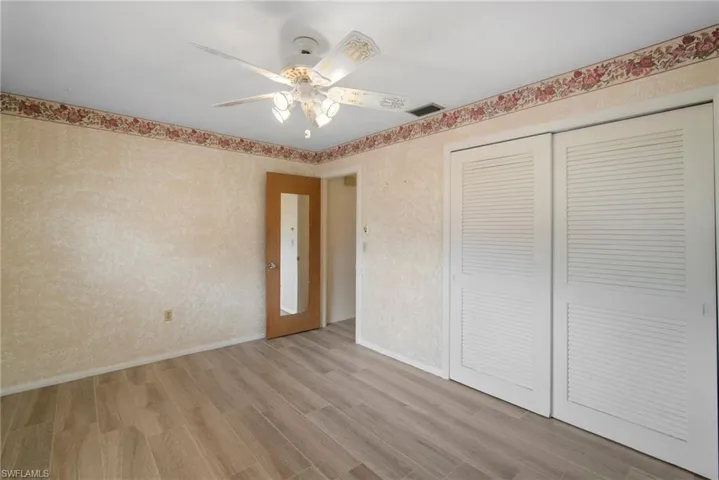 Unfurnished bedroom featuring light hardwood / wood-style flooring, a closet, and ceiling fan