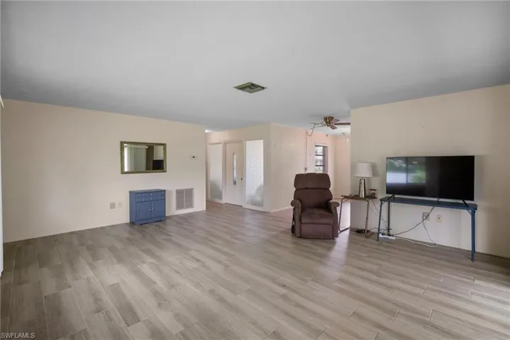 Unfurnished living room with ceiling fan and light wood-type flooring