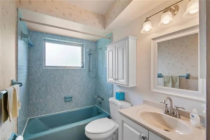 Full bathroom with toilet, vanity, and tiled shower / bath