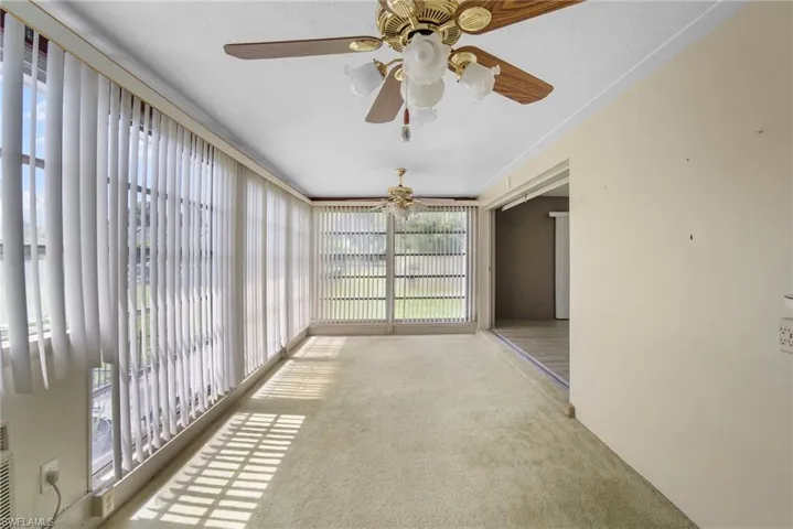 Unfurnished sunroom with ceiling fan