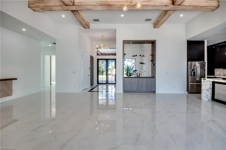 Entryway featuring beamed ceiling, a notable chandelier, and french doors
