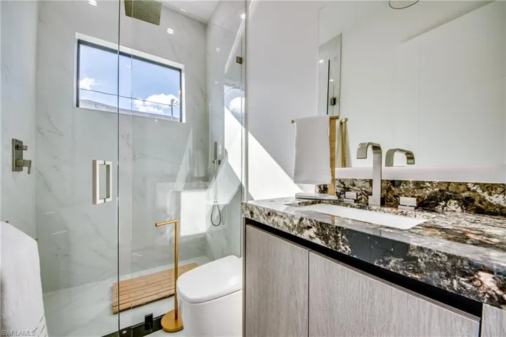 Bathroom with vanity, an enclosed shower, and toilet