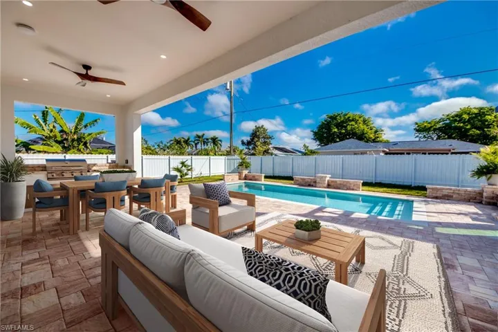 View of pool with ceiling fan, outdoor lounge area, area for grilling, and a patio