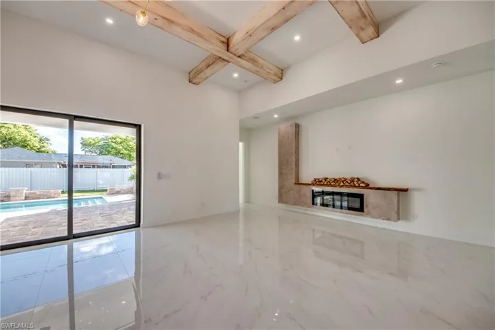 Unfurnished living room with beamed ceiling