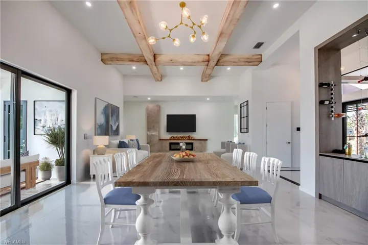 Virtually staged Dining area featuring beam ceiling and an inviting chandelier