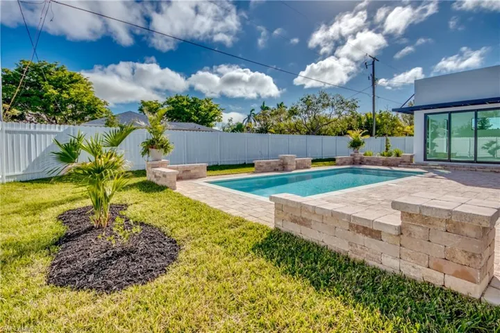 View of pool with a lawn and a patio