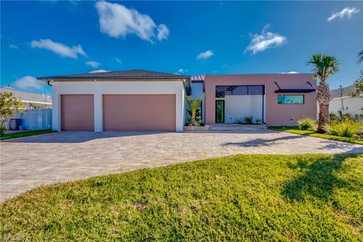 View of front facade featuring a front lawn and a garage