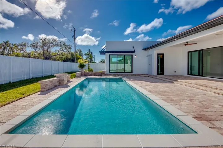 View of swimming pool with ceiling fan and a patio